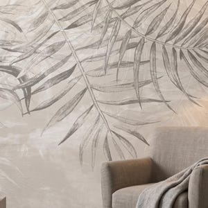 May include: A neutral-toned interior scene featuring a large-scale botanical mural with a palm leaf design. A gray armchair with a blanket, a floor lamp, and a decorative vase with a dried palm leaf complete the decor.