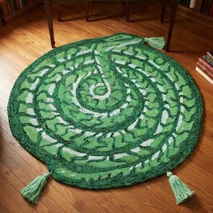 May include: A round green rug featuring a textured spiral pattern in varying shades of green and white. The rug is finished with three light green tassels attached to the outer edge, providing a decorative accent to the circular textile piece.