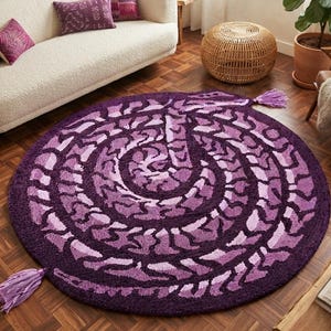 May include: A round, deep purple rug featuring a textured, spiralling pattern in varying shades of violet and lavender. The rug is finished with two light purple tassels attached to opposite sides of the circular edge, creating a distinct visual accent.