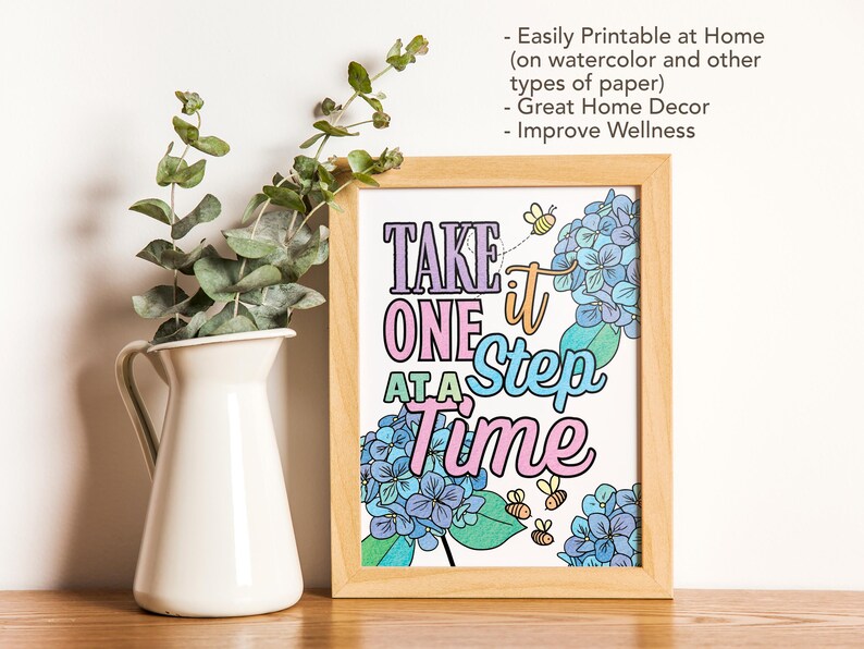 Puede incluir: Una p&aacute;gina para colorear imprimible con una cita motivacional, "Toma un paso a la vez", rodeada de flores azules y verdes y abejas. La cita est&aacute; escrita en una fuente colorida y juguetona.