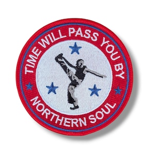 May include: A circular embroidered patch with a white centre and a red border. The text "TIME WILL PASS YOU BY" and "NORTHERN SOUL" is stitched in white. A black silhouette of a person dancing is centred with four blue stars surrounding it.