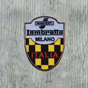 Pode incluir: Um remendo bordado branco, preto e amarelo com o texto "Innocenti Lambretta Milano Italia".