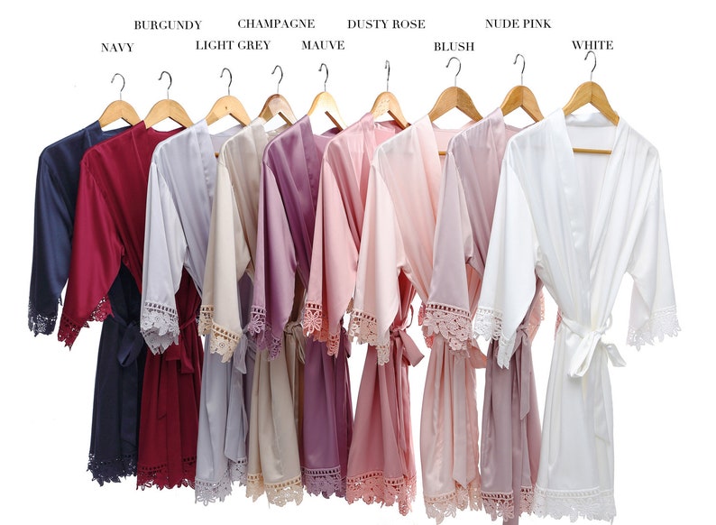 Pu&ograve; includere: Dieci accappatoi di raso in vari colori, tra cui blu navy, bordeaux, grigio chiaro, champagne, malva, rosa polvere, blush, rosa nude e bianco. Ogni accappatoio ha un bordo in pizzo e una cintura abbinata.
