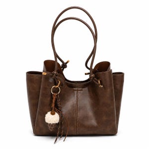 leather-tote-bag-women-work-tote-brown.Brown leather tote bag for women featuring a spacious vintage-inspired design, double shoulder straps, magnetic closure, and decorative charm, ideal for work, commuting, travel, and everyday use.