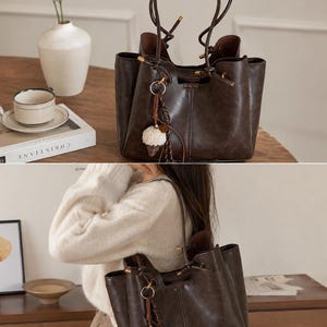 Brown leather tote bag for women featuring a spacious vintage-inspired design, double shoulder straps, magnetic closure, and decorative charm, ideal for work, commuting, travel, and everyday use.