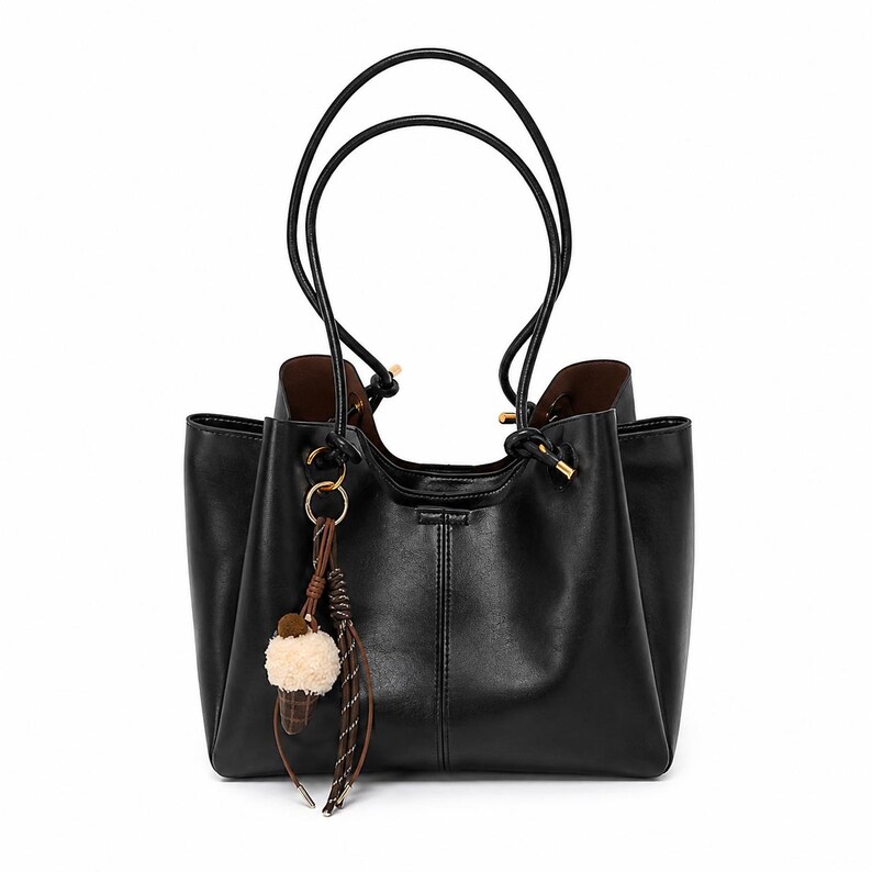 Brown leather tote bag for women featuring a spacious vintage-inspired design, double shoulder straps, magnetic closure, and decorative charm, ideal for work, commuting, travel, and everyday use.