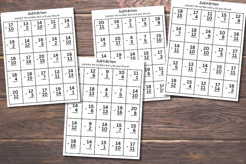 May include: Several subtraction worksheets with math problems printed on white paper. The worksheets are arranged on a wooden surface. The text "Subtraction" and instructions are visible on each sheet.