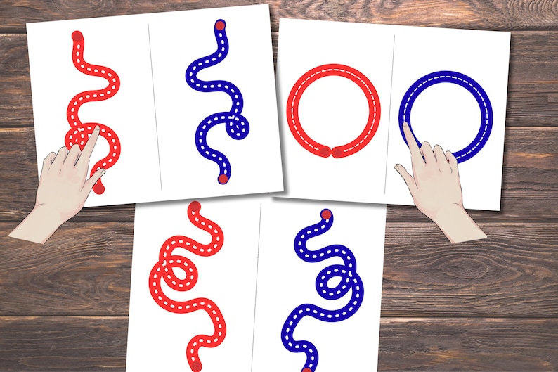 Pode incluir: Folhas de atividades educativas com exerc&iacute;cios de tra&ccedil;ado de linhas vermelhas e azuis. As folhas incluem formas curvas e circulares com linhas tracejadas para orienta&ccedil;&atilde;o. Uma m&atilde;o aponta para as linhas de tra&ccedil;ado em algumas folhas. O fundo &eacute; uma superf&iacute;cie de madeira.