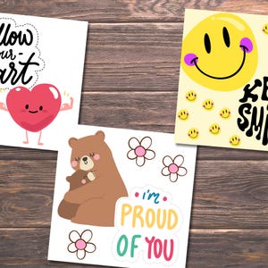 Puede incluir: Tres tarjetas imprimibles con mensajes positivos. La primera tarjeta presenta un coraz&oacute;n rojo con brazos y piernas, y el texto "Follow your heart". La segunda tarjeta presenta un oso marr&oacute;n abrazando a un oso m&aacute;s peque&ntilde;o, con el texto "I'm proud of you". La tercera tarjeta presenta una cara sonriente amarilla con el texto "Keep smiling".
