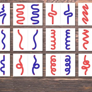 Pode incluir: Um conjunto de doze cart&otilde;es brancos, cada um dividido ao meio, exibindo desenhos de linhas curvas vermelhas e azuis. As linhas variam em forma, incluindo padr&otilde;es ondulados, zigue-zague e espirais. Os cart&otilde;es est&atilde;o dispostos sobre uma superf&iacute;cie de madeira.
