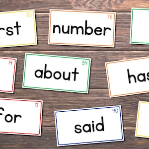 May include: Nine white cards with black text on a wooden background. The words on the cards are "first", "number", "will", "on", "about", "has", "for", "said", and "part".