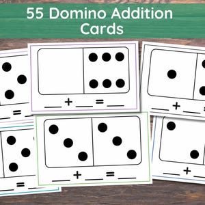 May include: 55 Domino Addition Cards with black dots on white backgrounds. Each card has a plus sign and equals sign, with spaces for numbers. The cards are arranged on a wooden surface, with a green banner at the top.