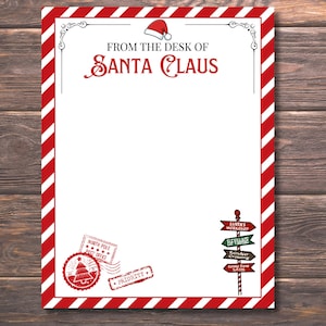 Peut inclure: Une feuille de papeterie sur le th&egrave;me de No&euml;l avec une bordure &agrave; rayures rouges et blanches. Le haut pr&eacute;sente le texte "FROM THE DESK OF SANTA CLAUS" et un bonnet de P&egrave;re No&euml;l. Comprend des timbres et un poteau indicateur.