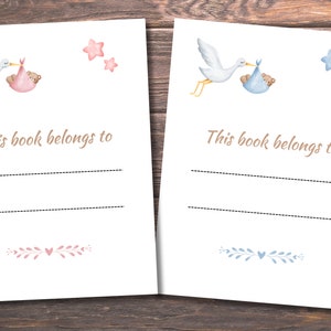 May include: Two blank bookplates featuring a stork carrying a baby in a blanket. The bookplate on the left has a pink blanket and stars, while the bookplate on the right has a blue blanket and stars. The text "This book belongs to" is printed on both bookplates.