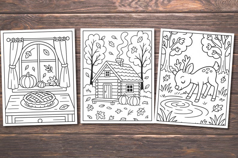 May include: Three black and white coloring pages featuring autumn themes. One shows a window with pumpkins and a pie, another a cabin with pumpkins, and the last a deer by a pond. The images are on a wooden background.