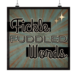 May include: A framed poster with the words "Fickle Fuddled Words" in a vintage style. The background has a teal and brown sunburst design. Two gold starbursts are in the upper right corner. The poster is held by two black clips.