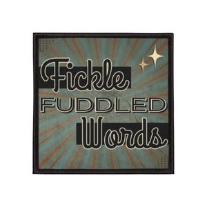 May include: Square patch with the words "Fickle Fuddled Words" in a retro font. The background is teal with orange and brown rays emanating from the center. Two gold stars are in the upper right corner.