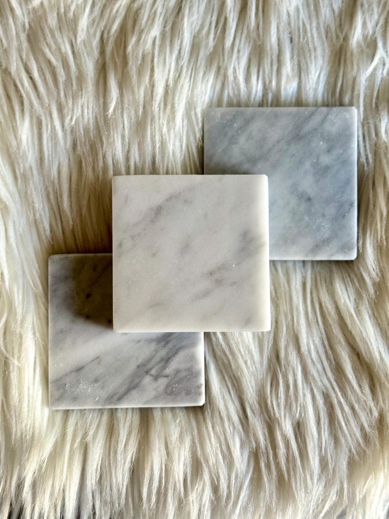 Sottobicchiere in marmo bianco Carrara dal design minimalista e raffinato. Superficie leggermente ruvida e angoli smussati. La forma quadrata e le dimensioni compatte li rendono perfetti per qualsiasi tipo di bicchiere, sia da vino che da cocktail.