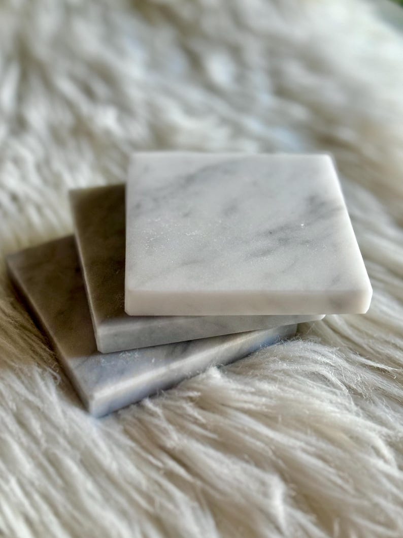 Sottobicchiere in marmo bianco Carrara dal design minimalista e raffinato. Superficie leggermente ruvida e angoli smussati. La forma quadrata e le dimensioni compatte li rendono perfetti per qualsiasi tipo di bicchiere, sia da vino che da cocktail.