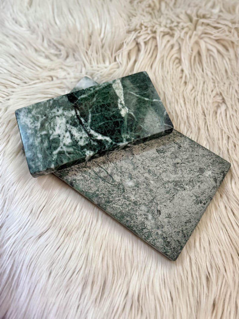 Vassoi in marmo Verde Guatemala dal colore verde intenso e costellati da vene bianche. Forma rettangolare, angoli totalmente smussati. Uno è lucido e l'altro è leggermente ruvido. Possono essere usati come portacandele o per accogliere vari oggetti.