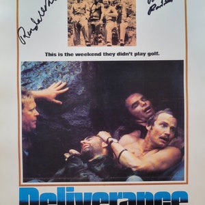 May include: A movie poster for the film "Deliverance" starring Jon Voight and Burt Reynolds. The poster features a scene from the film with three men in a dark, wooded area. The text "Deliverance" is in large, bold letters at the bottom of the poster. The poster also includes the tagline "This is the weekend they didn't play golf."