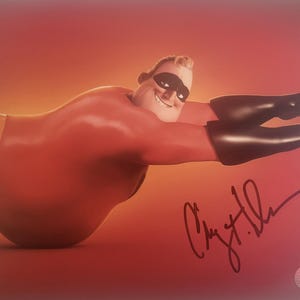 May include: A red and black superhero figure with a black mask and a signature. The signature reads "Chris Miller".