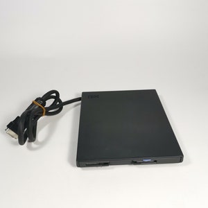 May include: A black external floppy disk drive with a black cable. The drive has the text "IBM" on the front.