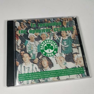 May include: A green and white CD case with a photo of a crowd of people wearing green and white clothing. The text on the case reads "The Green and White of Panathinaikos".
