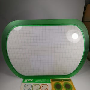 Può includere: Una lavagna magnetica a secco verde con un motivo a griglia. La lavagna misura 46 cm per 61 cm ed è fornita con un pennarello verde e magneti.