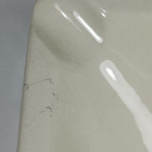 Puede incluir: Cenicero de cer&aacute;mica blanca con un borde ondulado y un ligero glaseado craquelado. El cenicero tiene una sola hendidura profunda para cigarrillos.