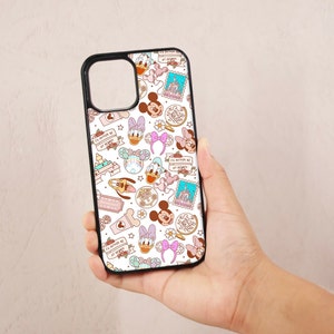 May include: A white phone case with a colorful pattern of Disney characters, including Mickey Mouse, Minnie Mouse, Donald Duck, and Goofy. The case features the text "I'd rather be at Disney" repeated throughout the design.