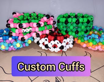 May include: A collection of colorful custom cuffs made of plastic beads. The cuffs are in various colors, including pink, green, red, white, black, blue, and rainbow. The text "Custom Cuffs" is displayed on a purple and blue background.