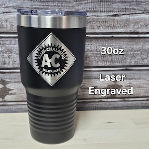 May include: Black 30oz tumbler with a silver rim and lid. The tumbler features a laser-engraved logo of "ALLIS-CHALMERS MILWAUKEE" in a diamond shape. The text "30oz" and "Laser Engraved" are also visible.