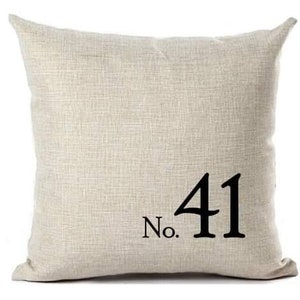 May include: A beige linen throw pillow with black text that reads "No. 41".