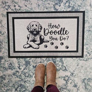 May include: A black and white doormat with the text "How Doodle You Do?" and a doodle dog illustration.