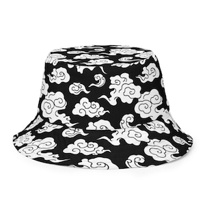 Puede incluir: Sombrero de pescador negro con un patrón de nubes blancas. Las nubes son estilizadas y se asemejan al arte japonés tradicional.