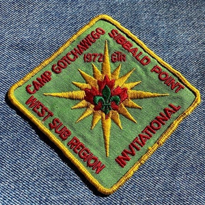 May include: A green and yellow diamond-shaped patch with the text "Camp Gotchawego 1972 GTR Sibbald Point West Sub Region Invitational" in red and white lettering. The patch features a yellow star with a red and green maple leaf in the center.