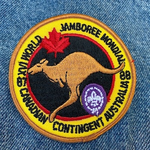 May include: An embroidered patch in yellow and red featuring a kangaroo, a maple leaf, and the text "1st Canadian Contingent World Jamboree Mondial Australia 85".