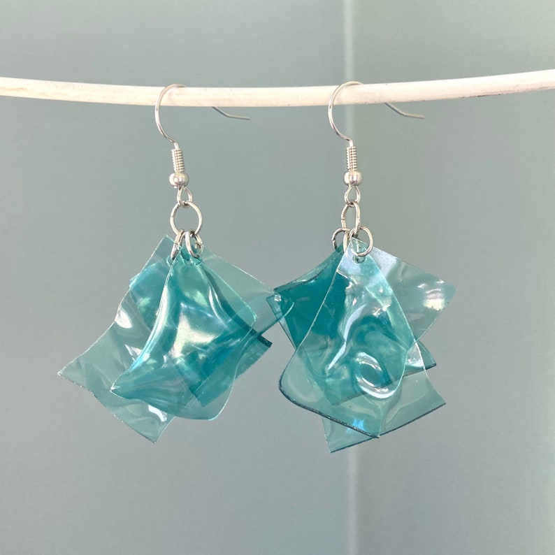 Recycled plastic blue earrings hanging from a wire.