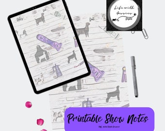 May include: A digital tablet displaying a printable show notes template with dog silhouettes, grooming clippers, and ribbons on a light wood background. A grey pen, paper clips, and pink petals surround the tablet and the printed page.