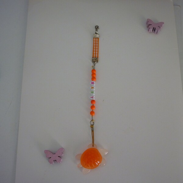 Bijou de portable MARY, perles orange fluo, ruban et tortue.