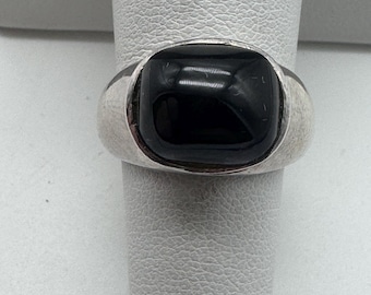 May include: A silver ring with a black square-shaped gemstone.