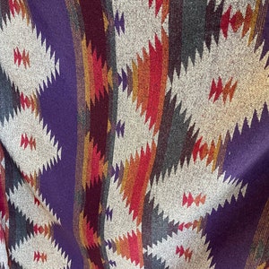 May include: A woven fabric with a geometric pattern in shades of purple, red, orange, brown, and white.