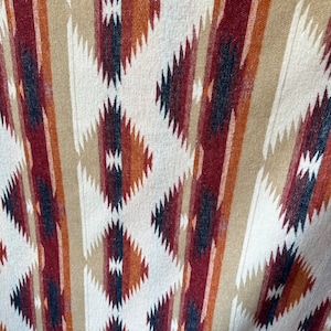 May include: A woven fabric with a geometric pattern in shades of brown, red, and white. The pattern is made up of stripes and diamonds.