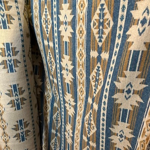 Könnte beinhalten: Nahaufnahme eines Stoffes mit einem geometrischen Muster in Blau und Braun. Das Muster besteht aus Streifen und Rauten. Der Stoff ist gewebt und hat eine strukturierte Oberfläche.