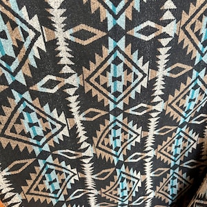 May include: Black fabric with a geometric pattern in shades of brown, blue, and white. The pattern is reminiscent of Native American designs.