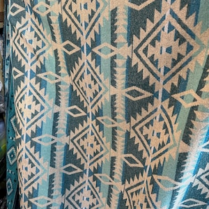 Peut inclure: Un tissu tissé avec un motif géométrique dans des tons de bleu et de beige. Le motif présente des formes de diamants et des triangles qui se répètent.