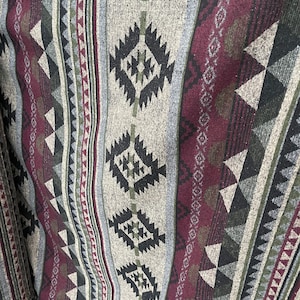 May include: A close-up of a woven fabric with a geometric pattern in shades of grey, black, burgundy, and green.