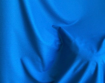 May include: A smooth, wrinkle-free, solid blue fabric background.