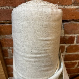 May include: A roll of off-white fabric with a slightly textured surface.